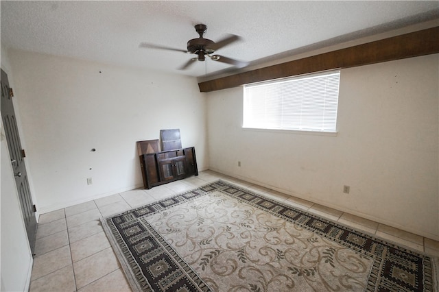 tiled empty room featuring ceiling fan and a textured ceiling