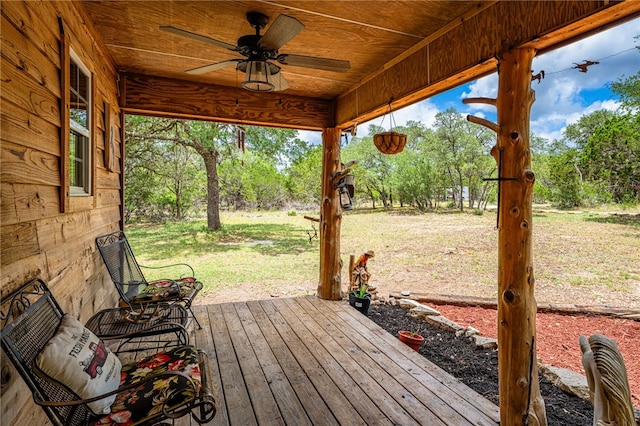 wooden terrace with a lawn and ceiling fan