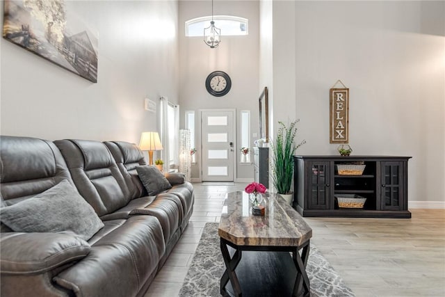 15417 Palmira Ave Unit B, Corpus Christi, TX 78418 - living room with light wood-style flooring, a towering ceiling, and baseboards