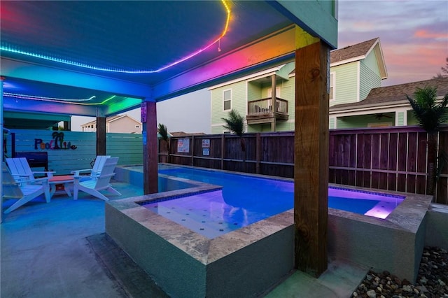 268 Flounder Dr, Port Aransas, TX 78373 - pool at dusk with a fenced backyard, a pool with connected hot tub, and a patio area