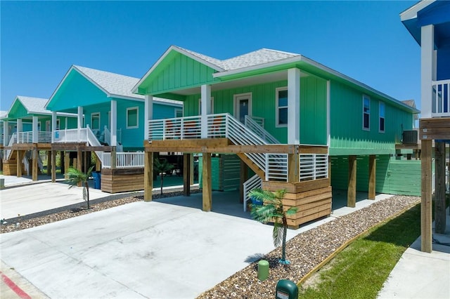 268 Flounder Dr, Port Aransas, TX 78373 - beach home with stairs, a carport, concrete driveway, board and batten siding, and roof with shingles