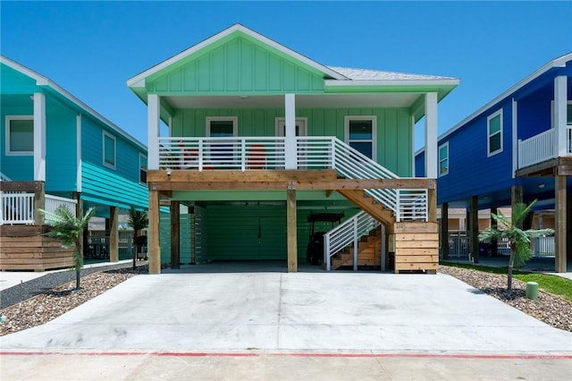 268 Flounder Dr, Port Aransas, TX 78373 - beach home with board and batten siding, concrete driveway, a carport, stairway, and covered porch