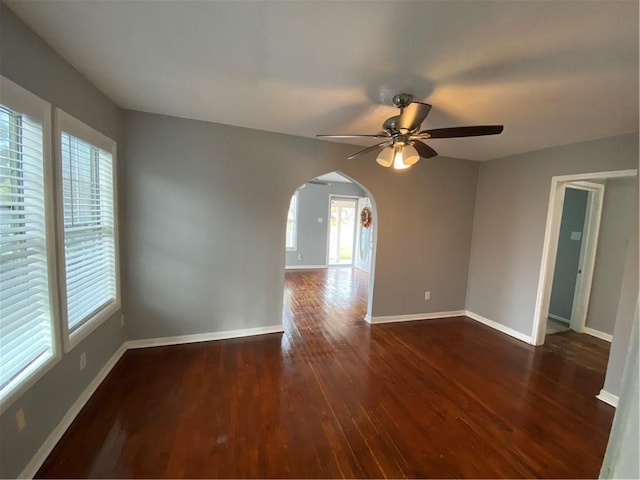 empty room with ceiling fan and dark hardwood / wood-style flooring