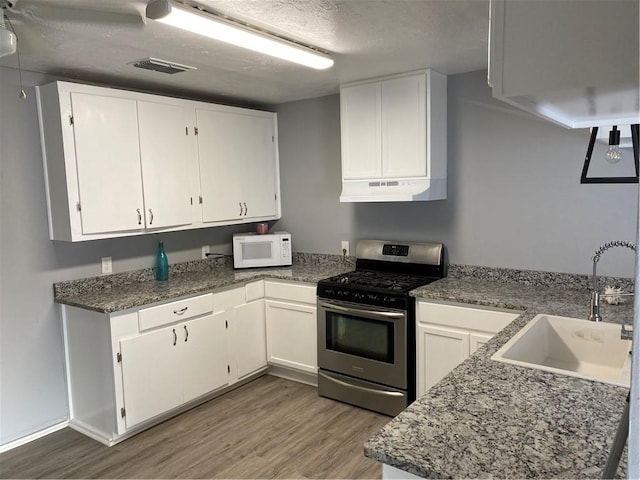 kitchen with white cabinetry, sink, and stainless steel gas range