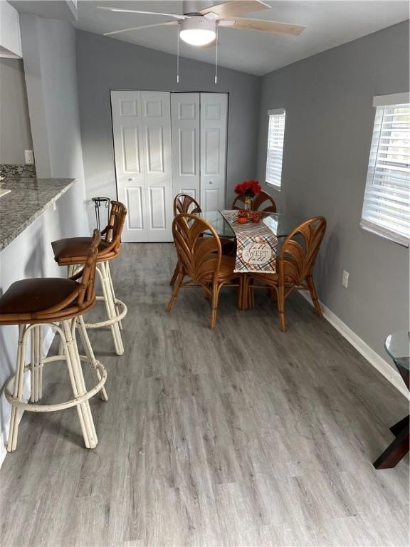 dining space featuring hardwood / wood-style flooring, lofted ceiling, a wealth of natural light, and ceiling fan