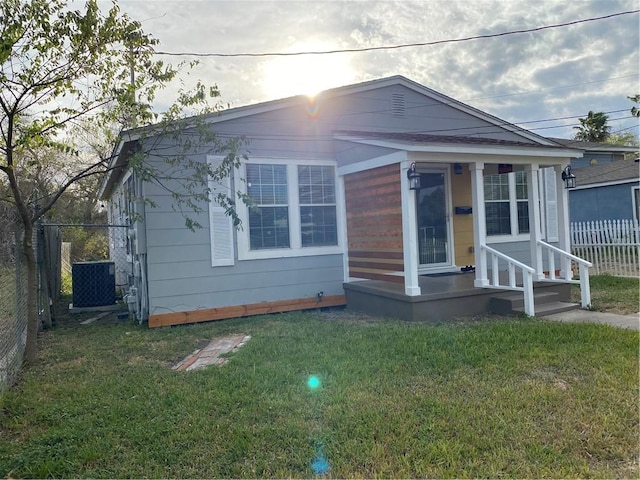 bungalow-style home with cooling unit and a front lawn