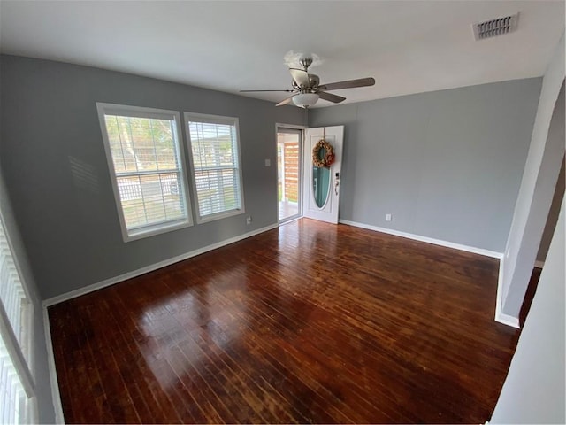 empty room with dark hardwood / wood-style flooring and ceiling fan