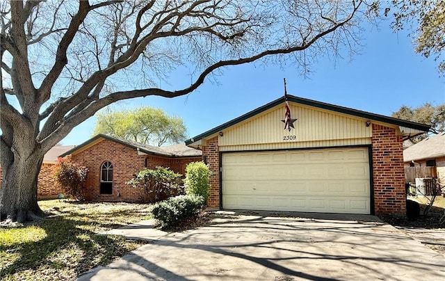 ranch-style home featuring brick siding, driveway, and a garage