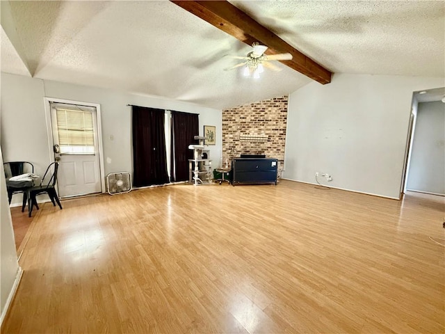 unfurnished living room with a textured ceiling, vaulted ceiling with beams, light wood-type flooring, and a ceiling fan