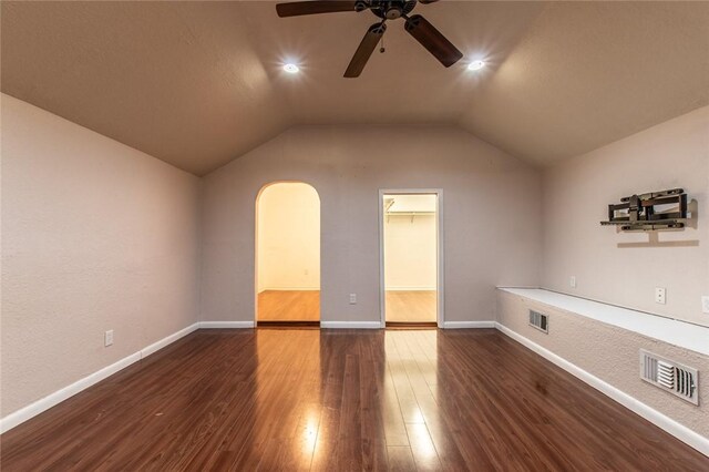 unfurnished room featuring visible vents, lofted ceiling, and wood finished floors