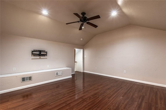 interior space featuring visible vents, baseboards, dark wood-style floors, and vaulted ceiling