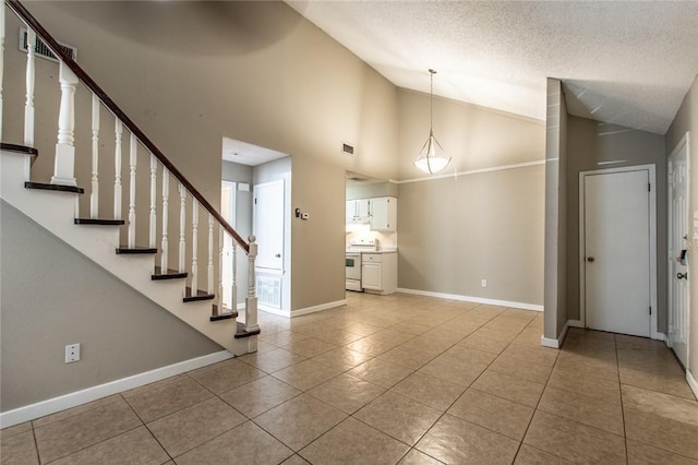 entryway with visible vents, a textured ceiling, light tile patterned flooring, baseboards, and stairs