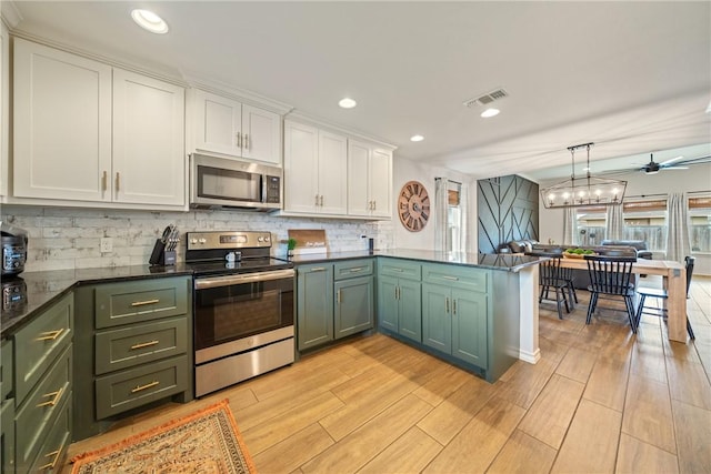 kitchen with ceiling fan, white cabinets, decorative light fixtures, and appliances with stainless steel finishes