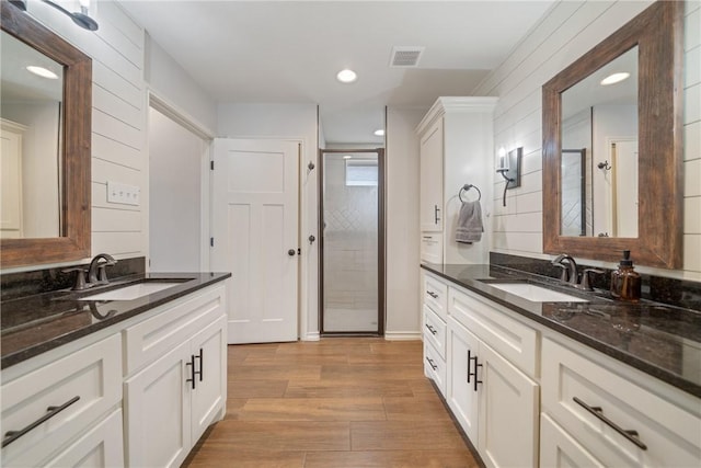 bathroom with vanity, wood-type flooring, and walk in shower