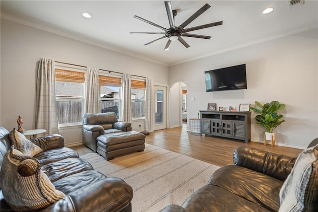 living room with ceiling fan, light wood-type flooring, and ornamental molding