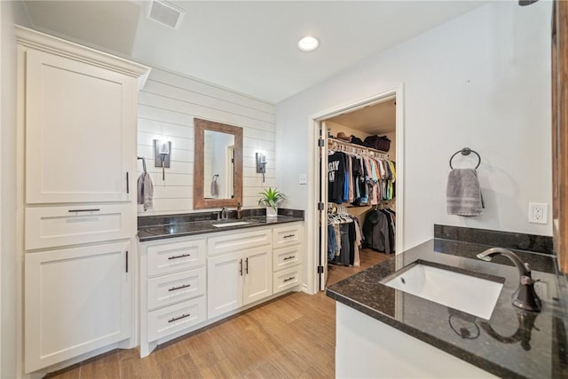 bathroom featuring wooden walls, vanity, and hardwood / wood-style flooring