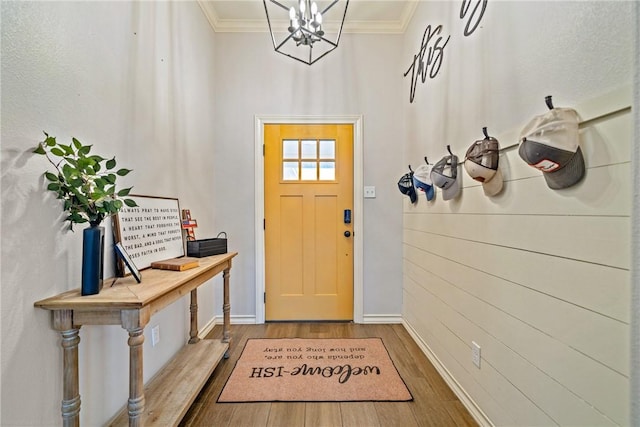 entrance foyer featuring hardwood / wood-style floors, a notable chandelier, and crown molding