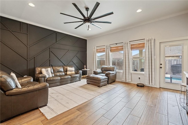 living room featuring light wood-type flooring, ceiling fan, and ornamental molding