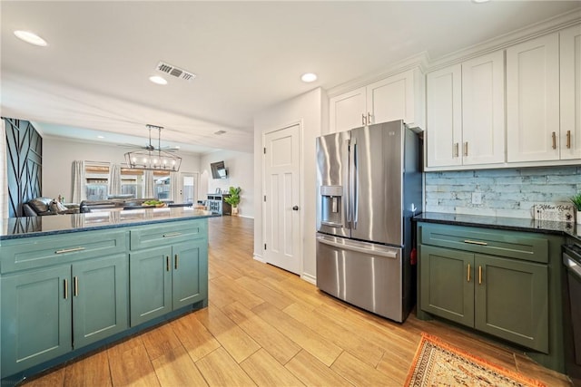 kitchen featuring tasteful backsplash, stainless steel appliances, pendant lighting, light hardwood / wood-style flooring, and white cabinets