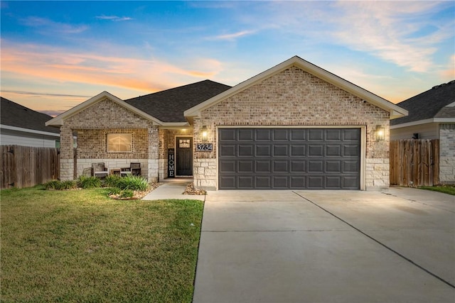 ranch-style home with a garage and a yard