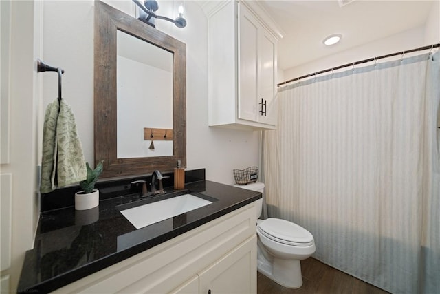 bathroom with curtained shower, toilet, vanity, and hardwood / wood-style flooring