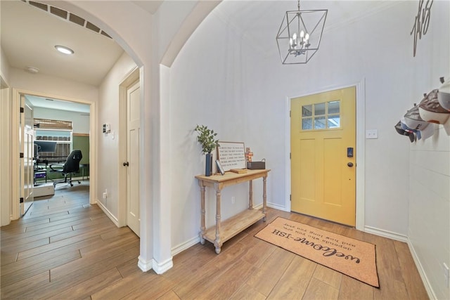 foyer with a chandelier and wood-type flooring