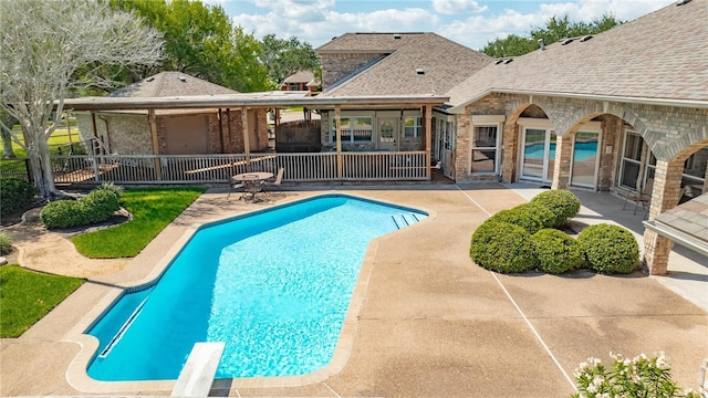 view of pool with a patio area and a diving board