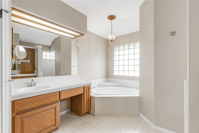 bathroom with vanity, plenty of natural light, tile patterned floors, and tiled tub