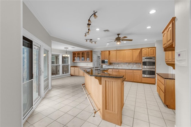 kitchen featuring stainless steel appliances, crown molding, backsplash, hanging light fixtures, and a kitchen island with sink