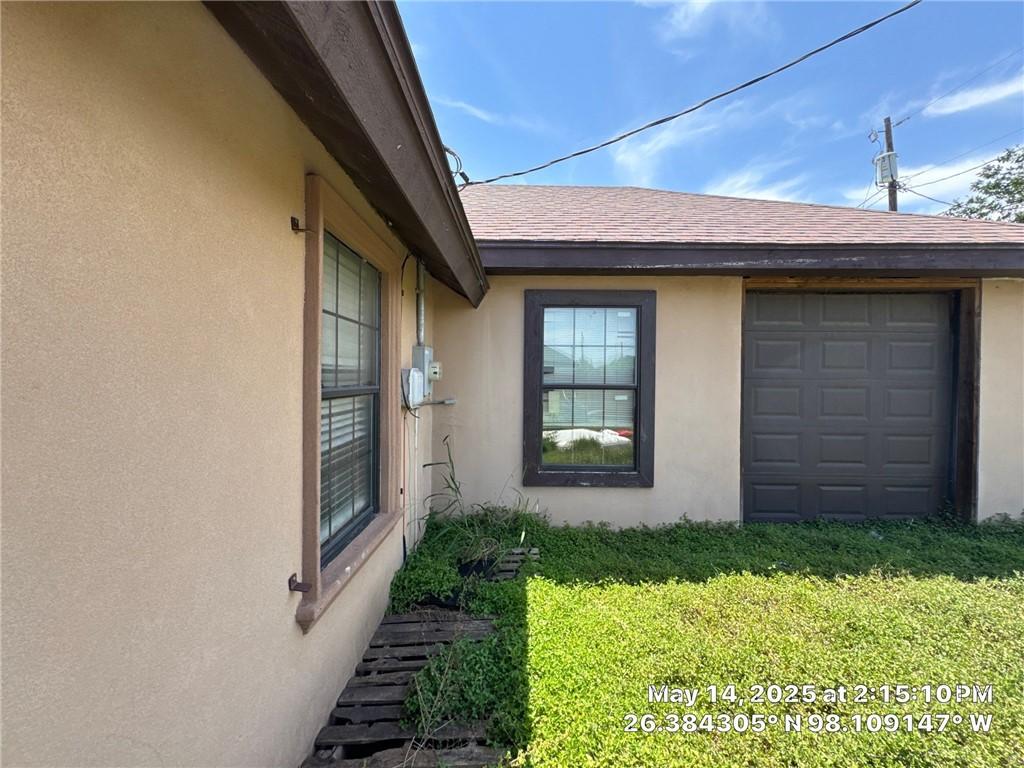 3309 Tulipan Ave, Edinburg, TX 78542 - view of side of home with stucco siding, a yard, a garage, and a shingled roof