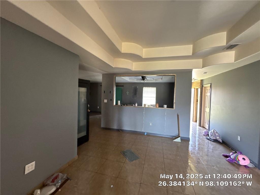 3309 Tulipan Ave, Edinburg, TX 78542 - tiled empty room featuring a tray ceiling, ceiling fan, and baseboards