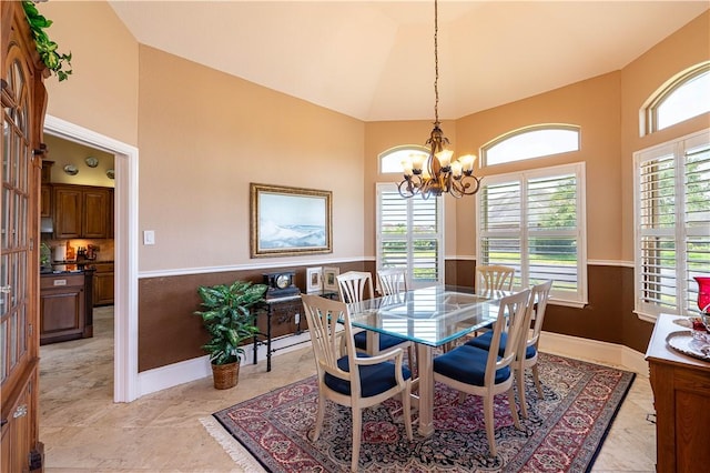 dining area featuring lofted ceiling and a notable chandelier