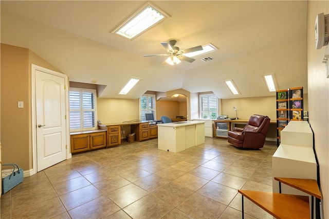 interior space with lofted ceiling, light tile patterned floors, a center island, and ceiling fan