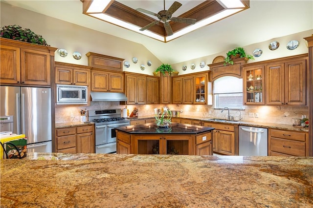 kitchen featuring lofted ceiling, sink, dark stone countertops, decorative backsplash, and stainless steel appliances