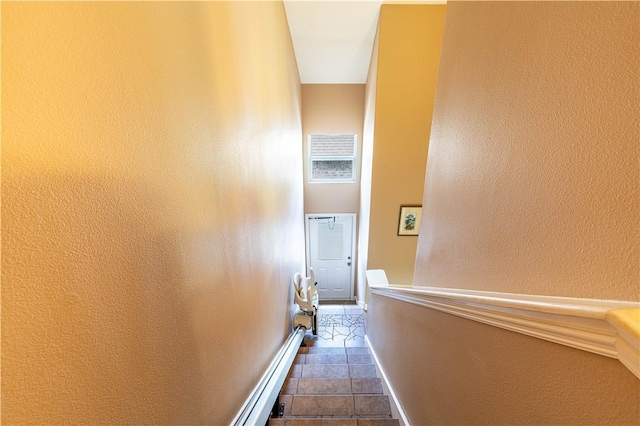 hallway featuring a baseboard radiator and dark tile patterned flooring