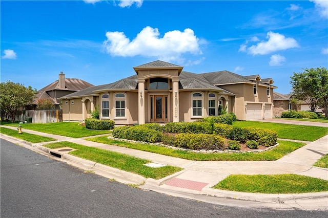 mediterranean / spanish home featuring a garage and a front lawn