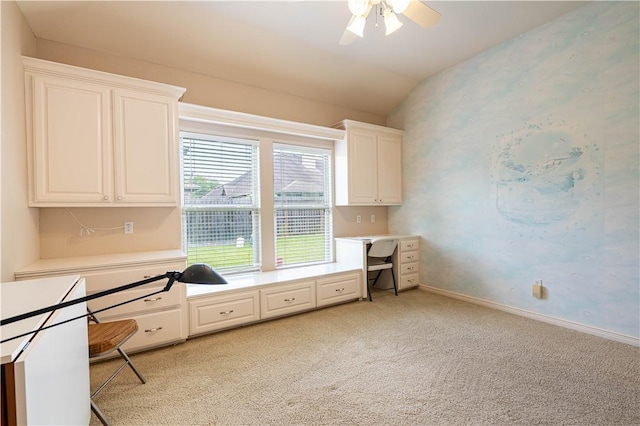 unfurnished office featuring vaulted ceiling, light colored carpet, and ceiling fan