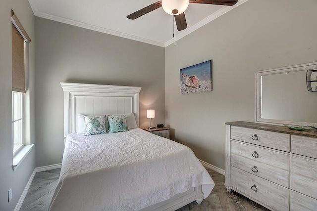 bedroom with ceiling fan, wood finished floors, baseboards, and ornamental molding