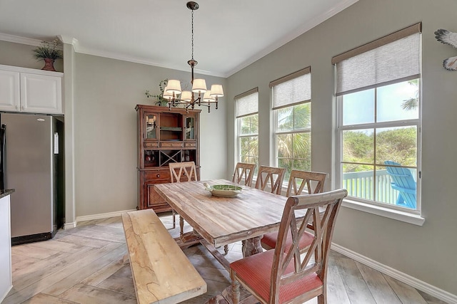 dining room with a chandelier, parquet flooring, baseboards, and ornamental molding