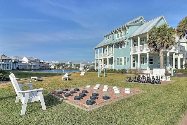 back of house with a patio, a balcony, a lawn, and a residential view