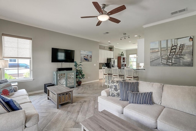 living area featuring crown molding, baseboards, and visible vents