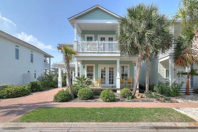 view of front of property featuring a balcony, french doors, and covered porch