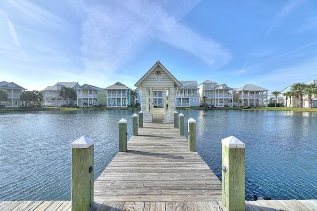 view of dock with a residential view and a water view