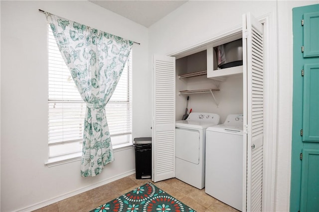 clothes washing area featuring light tile patterned flooring and washer and clothes dryer