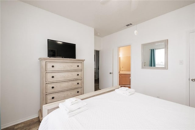 bedroom featuring connected bathroom and wood-type flooring