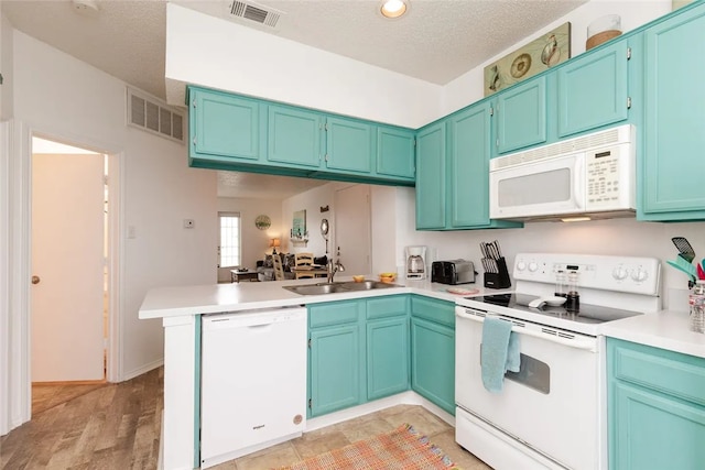 kitchen featuring a textured ceiling, white appliances, sink, kitchen peninsula, and light hardwood / wood-style flooring