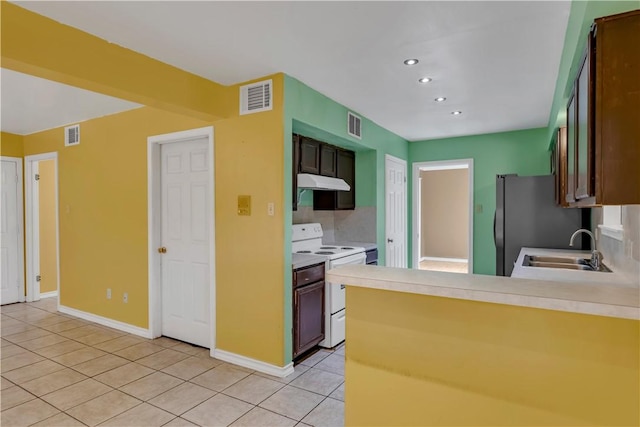 2826 Toronto Dr, Corpus Christi, TX 78414 - kitchen with white range with electric cooktop, under cabinet range hood, a sink, light tile patterned flooring, and freestanding refrigerator