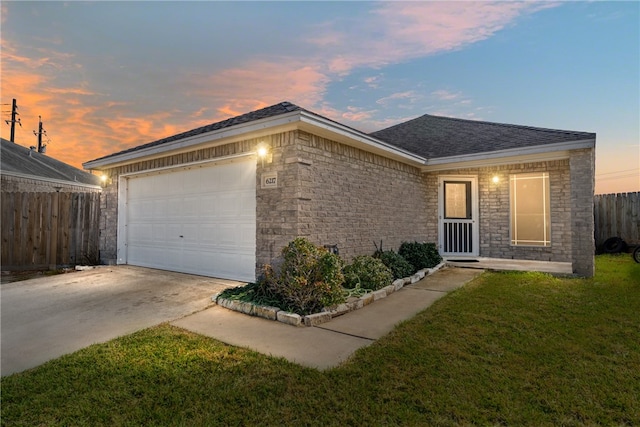 ranch-style house featuring a lawn and a garage