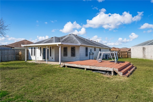 back of property featuring a wooden deck and a yard