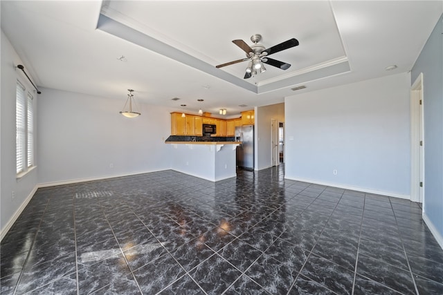 unfurnished living room featuring a tray ceiling, ceiling fan, and crown molding